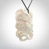 This is a hand carved bone baby dragon pendant. It is made from bone and has an adjustable black coloured cord. This is a large sized necklace and is a very unique, one only, pendant that is a piece for art lovers.